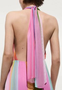 Vue arrière d'une robe sans manches présentant des rayures verticales pastel en rose, orange et vert, avec un noeud rose flottant au niveau du col.
