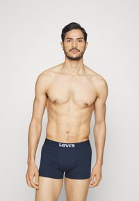 Boxers en jersey bleu marine en coton, présentant un logo Levi's blanc sur la ceinture élastique, coupe ajustée et texture lisse.