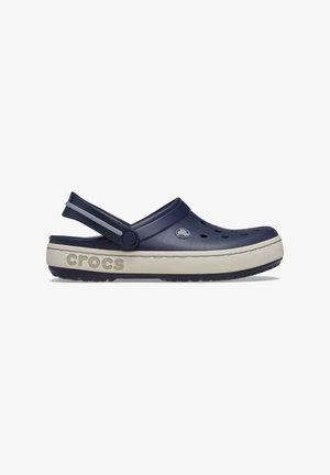 Sabot Crocs bleu marine avec bride de talon réglable, trous de ventilation et semelle beige arborant le logo Crocs en relief.