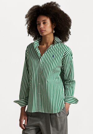 Camisa de botones a rayas verdes y blancas con cuello extendido, que presenta un pequeño logo azul en el pecho y mangas largas. Tejido texturizado.