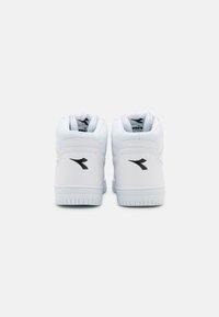 Valkoiset korkeavartiset tossut, joissa on sileä nahkapinta, pehmustettu nilkkareuna, mustat logo-yksityiskohdat ja kumipohja, jossa on kuvioitu pito.