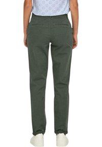Pantaloni in cotone verde con vestibilità dritta, dotati di tasche posteriori e design pulito. Indossati con sneakers bianche.