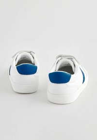 Baskets blanches avec des accents bleus, dotées d'un bout rond, d'une texture lisse, de lacets en velcro et d'un onglet au talon en contraste. Design épuré et sportif.
