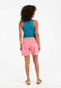 Roze katoenen shorts met opgerolde zomen, twee achterzakken en een gemusterde tailleband, gecombineerd met een blauwe tanktop.