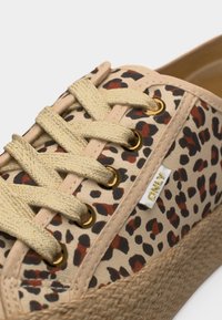 Μπλε καμβάς αθλητικών παπουτσιών με μπεζ βάση, λεοπάρ μοτίβο σε μαύρο και καφέ, μπεζ κορδόνια, χρυσά μεταλλικά τεμάχια και πλεκτή υφή στη σόλα πλατφόρμας.