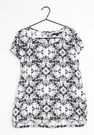 Blusa a maniche corte con motivo bianco e nero, dal fit morbido, scollatura a barca e orlo leggermente curvo. Tessuto leggero con una texture liscia.