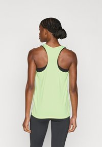 Αθλητική φανέλα σε ανοιχτό πράσινο χρώμα με σχεδιασμό racerback και μαύρες λεπτομέρειες. Ομαλή υφή με άνετη εφαρμογή, σχεδιασμένη για άνεση κατά την άσκηση.