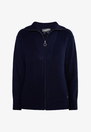 Navy blue knitted zip-up sweater with a high collar, ribbed texture, and a circular zipper pull. Features a fitted silhouette and long sleeves.