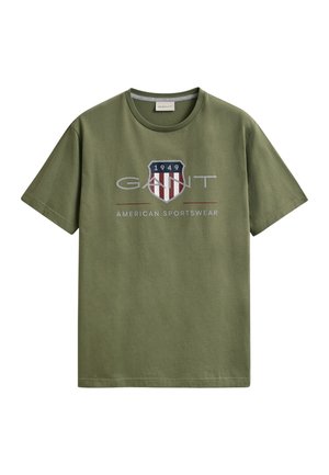 Alyvuogių žalios spalvos trumpomis rankovėmis medvilniniai marškinėliai su apvalia iškirpte, priekyje esantis skydelio logotipas su tekstu „1949“ ir „GANT American Sportswear“.