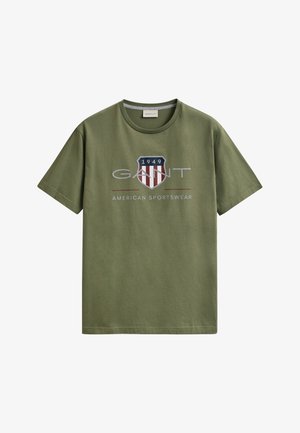 Oliwkowo-zielony bawełniany T-shirt z krótkim rękawem i okrągłym dekoltem, z nadrukiem logo tarczy z napisem "1949" oraz "GANT American Sportswear" na przodzie.