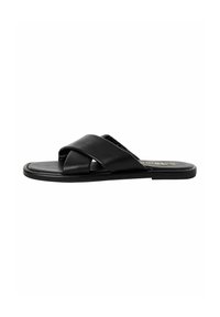 Black leather slide sandal with crossed straps, flat sole, and a smooth texture. Gold logo on insole. Minimalist design.