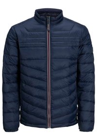 Giacca imbottita blu navy con colletto alto, trapuntatura verticale e zip frontale con un accento rosso a contrasto. Texture morbida, design leggero.