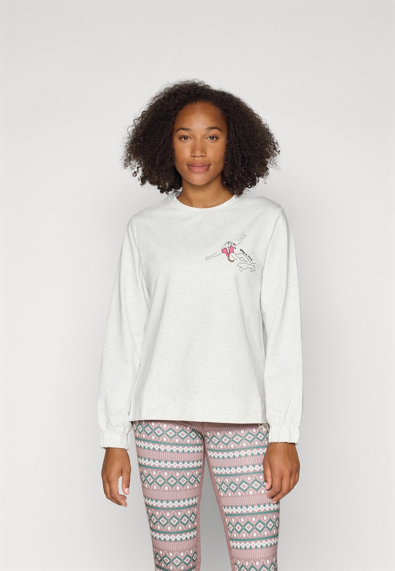Helles graues Langarm-Sweatshirt mit einem gestickten rot-weißen Design. Kombiniert mit gemusterten Leggings in Rosa, Weiß und Grün.