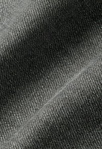 Grijze katoenstof met een zachte textuur, voorzien van een subtiel geribbeld patroon en een lichte glans, die het geweven ontwerp en de warmte benadrukt.