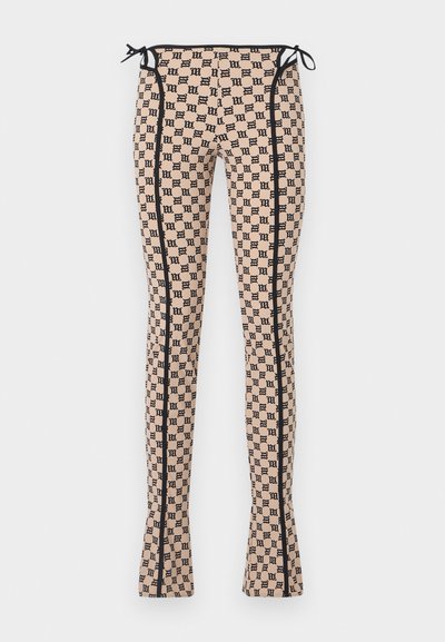 Patroonleggings in een lichte perzikkleur met een zwart logo-print, met zwarte zijnaad en strikjes in de taille. Uitlopende design.