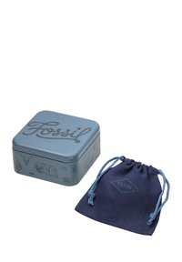 Boîte cadeau carrée en métal bleu avec logo "Fossil" embossé et illustrations. Pochette en tissu douce de couleur marine avec des accents de bleu plus clair.