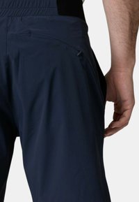 Pantaloni da esterno blu navy con un tessuto leggero e liscio; presentano una tasca laterale e una vita elastica per comfort e flessibilità.