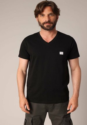 Zwarte katoenen V-hals T-shirt met korte mouwen en een klein borstzakje met een merklabel. Gladde textuur, slim fit ontwerp.