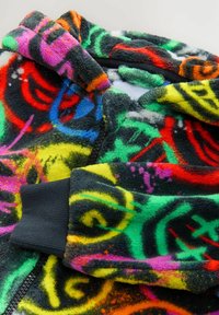 Fleece zip-up hoodie featuring a colorful abstract design in red, green, yellow, and pink with black accents on the cuffs and zipper.