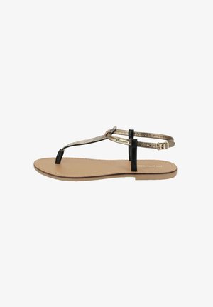 Flad tætsiddende sandal med en sort rem og en metallisk guldaccent. Beige fodseng med en glat overflade og minimalistisk design. Justerbar ankelrem.