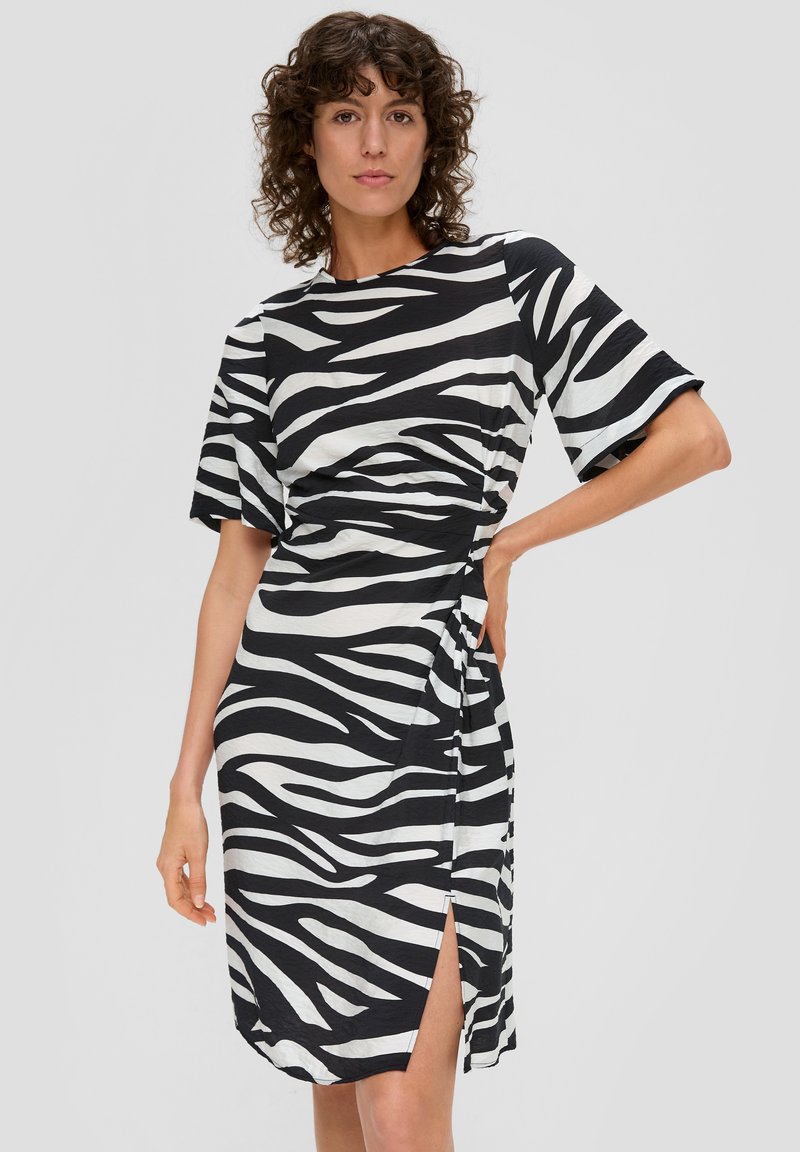 Vestido con estampado de cebra en blanco y negro, con mangas cortas, diseño cruzado y abertura lateral. Hecho de una tela suave y ligera para mayor comodidad.