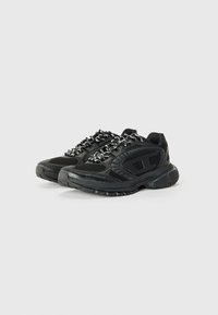 Chaussures de sport noires avec des panneaux en maille, des semelles texturées et des lacets réfléchissants. Elles présentent un col rembourré et un simple accent de logo sur le côté.