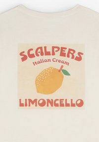 Valkoinen t-paita, jossa on graafinen printti sitruunasta ja punaisella tekstillä "SCALPERS Italian Cream Limoncello."