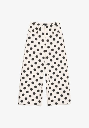 Balti platām kājām bikses ar melniem punktiņiem, priekšējām kabatām un pogu un rāvējslēdzēja aizdari viduklī.