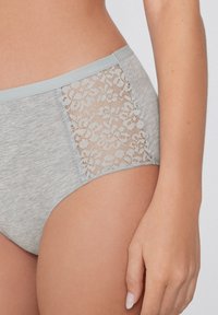 Šedé bavlněné kalhotky s vysokým pasem, které mají krajkovou vsadku s květinovým vzorem po straně, a světle šedý elastický pas.