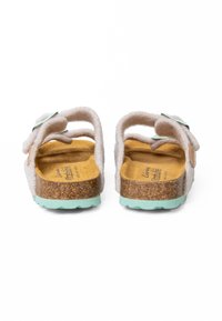 Sandales en feutre gris clair avec un pied en liège et une semelle extérieure vert menthe. Présente un design à double sangle et des accents en texture douce.