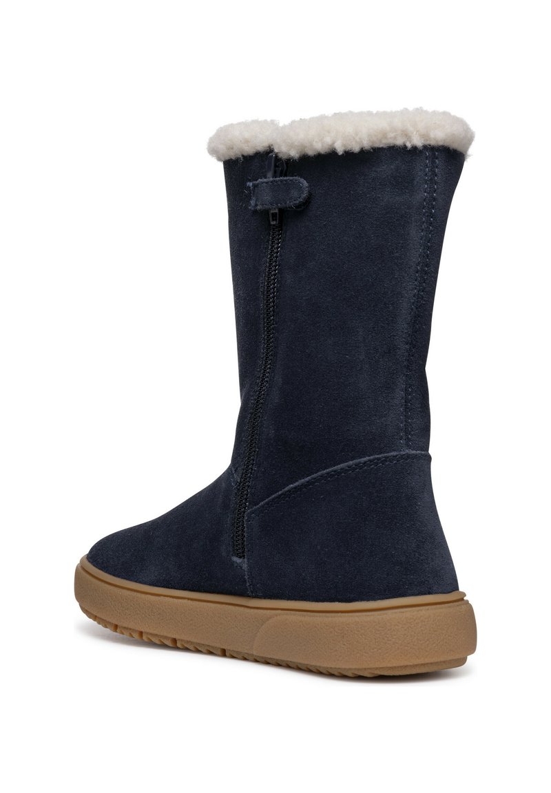 Dunkelblaue Wildleder-Stiefelette mit einem cremefarbenen Kunstfellkragen, innem Reißverschluss und einer braunen strukturierten Gummisohle. Glatte Oberfläche, robuste Verarbeitung.