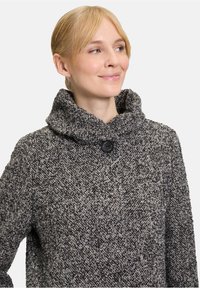 Gestructureerde, grijs-zwarte gebreide jas met een hoge kraag, enkele knoopsluiting en losse pasvorm, met een subtiel visgraatmotief.