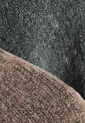 Textil s texturou v odstínech šedé a hnědé, s hladkým zakřivením a mírně chlupatým povrchem. Pozadí je tmavší s matnou texturou.