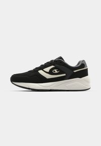 Black athletic shoes with a mesh and synthetic upper, featuring a white logo and accents, thick white midsole, and textured black outsole.