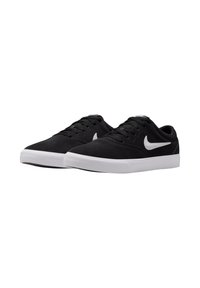 Black canvas sneakers with a white rubber sole and white Nike swoosh. Features a low-top design and round laces for secure fit.