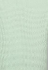 Lichtgroene gebreide trui met een gestructureerd, wafervormig patroon. Lichtgewicht materiaal, ronde halslijn en lange mouwen.