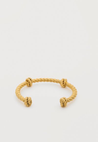 Χρυσόχρωμο βραχιόλι με στριφογυριστό σύρμα και τέσσερις ομοιόμορφα τοποθετημένους κόμπους σε απλό λευκό φόντο.