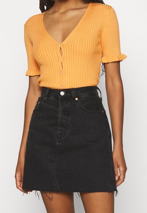 Haut orange à rayures et à manches courtes avec un décolleté en V profond et des boutons sur le devant, associé à une mini-jupe en denim noir avec des bords effilochés.