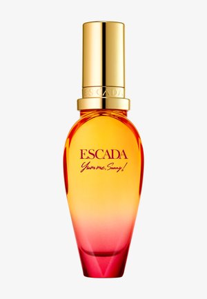 Flacon de parfum Escada Yum me, Sunny ! en verre dégradé orange vers rose avec un bouchon doré brillant sur fond blanc.