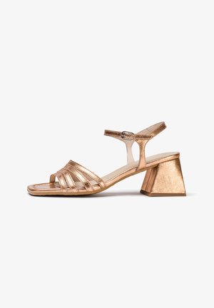 Women's metallic rose gold sandal with low block heel, adjustable ankle strap, and multiple front straps over toes.