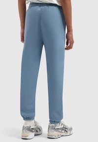 Lichtblauwe sweatpants met een taps toelopende pasvorm en elastische boorden, gemaakt van zachte stof. Heeft een ontspannen tailleband voor comfort.