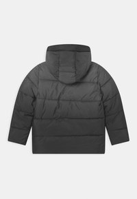 Chaqueta acolchada negra con capucha, que presenta un diseño acolchado, mangas cortas y una textura suave y brillante. Sin hardware o acentos visibles.