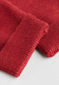 Red knit fabric with a smooth texture, featuring ribbed cuffs and a close-up view of the weave pattern. Soft and slightly fuzzy appearance.