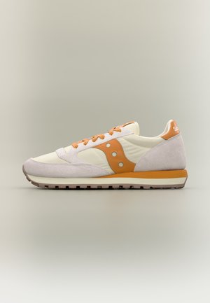 Pantof sport cu profil jos în crem și portocaliu cu accente din piele întoarsă, șireturi portocalii și talpă din cauciuc texturată, văzut din partea dreaptă.