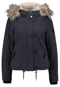 Marineblå polstret jakke med prikket mønster, hætte med pelskant, frontknapper og sidelommer med lynlås. Justerbar snøre i kanten.