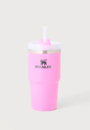 Pink isoleret rejsekrus med hvidt låg og sugerør, Stanley-logo i sort på fronten, mod en lys grå baggrund.