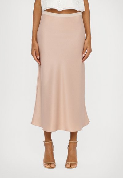 A long, blush satin skirt with a smooth texture and a slight flare. Features a fitted waistband and is paired with beige heeled sandals.