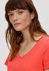 Koraalrood V-hals T-shirt van lichtgewicht, gestructureerde stof, met korte mouwen en een relaxed fit. Ontworpen voor casual gebruik.