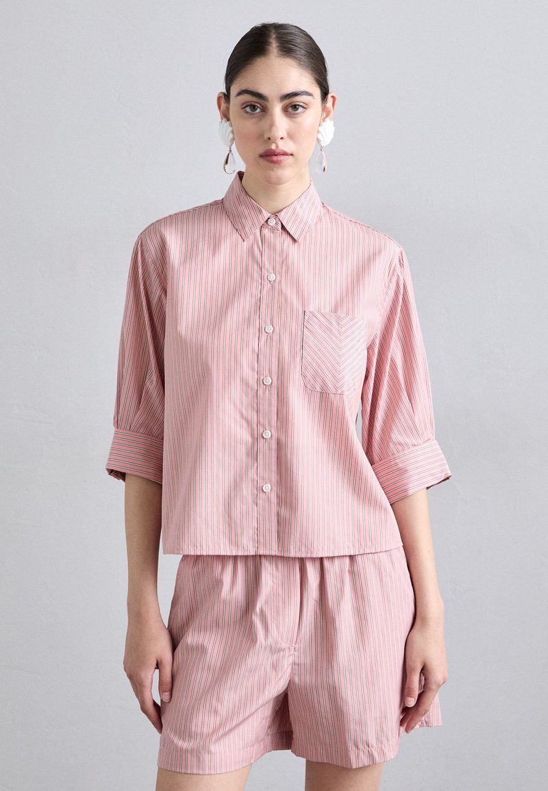 Pink short-sleeve button-up shirt with white and blue vertical stripes, featuring a chest pocket and a relaxed fit. Paired with matching shorts.