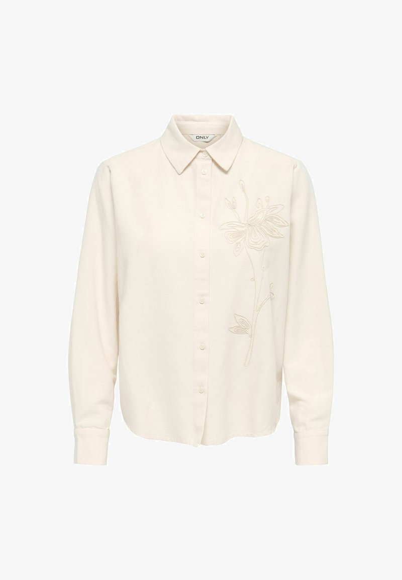 Chemise crème à manches longues avec col et broderie florale subtile sur le côté droit.